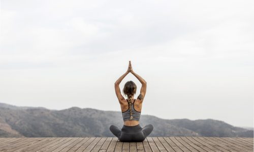 femme de dos faisant du yoga